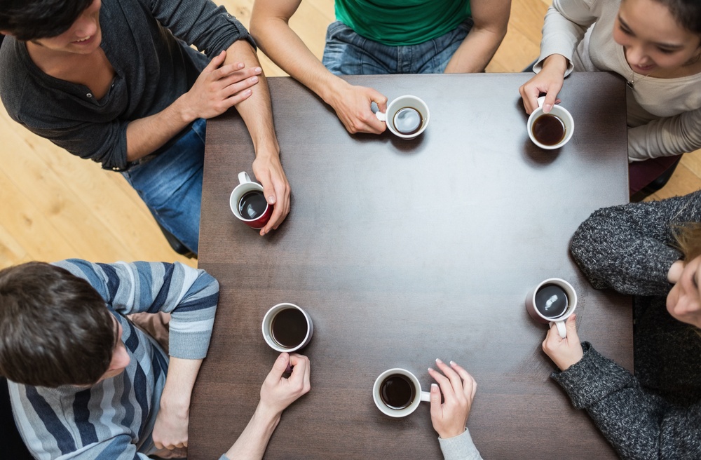 Ansatte tar seg en pust i bakken med hver sin kaffekopp