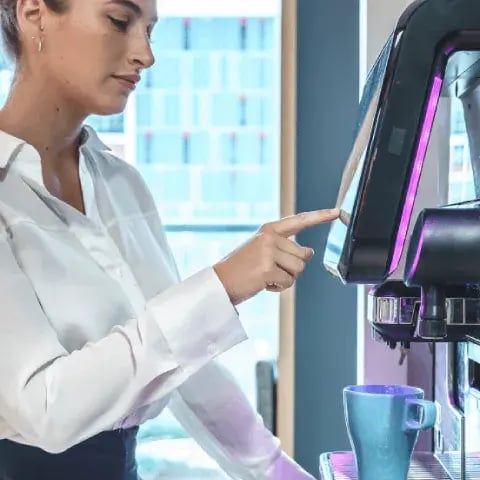 KAFFE TIL DE ANSATTE_businesswoman-making-drink-in-coffee-machine-in-of-2023-11-27-05-07-31-utc