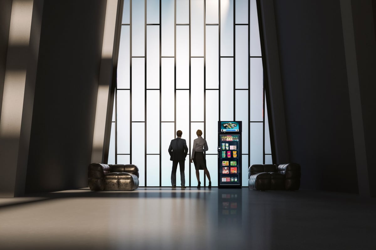 To personer ved en smart vending med snacks og drikke i en lobby