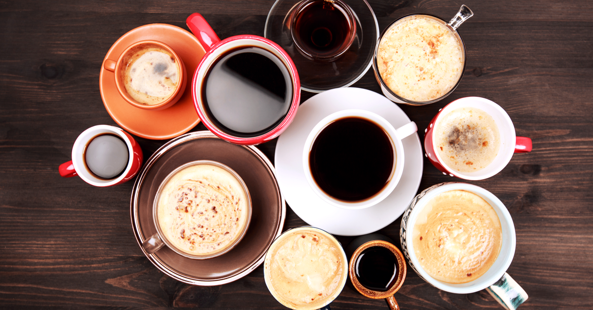 Mange fargerike kaffekopper samlet i en ring på et bord. Guide til kaffe på jobben.
