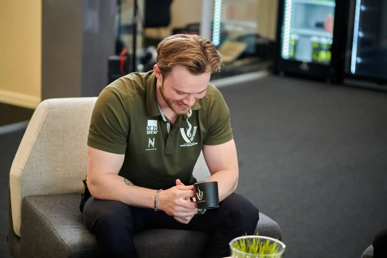 Smilende rådgiver fra v:aroma med kaffekopp