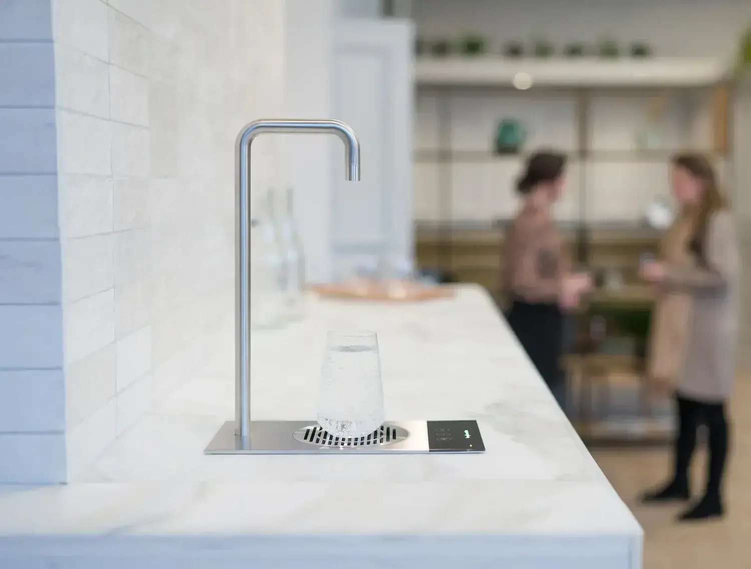 Glass med kullsyret vann på tappekranen Borg & Overström T2, på en marmorbenk