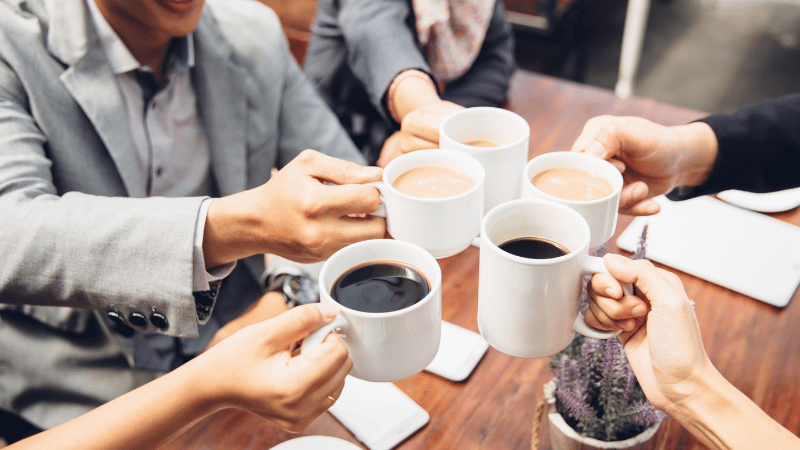 en gruppe ansatte drikker kaffe sammen 