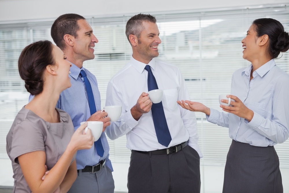 Cheerful work team during break time in bright office.jpeg