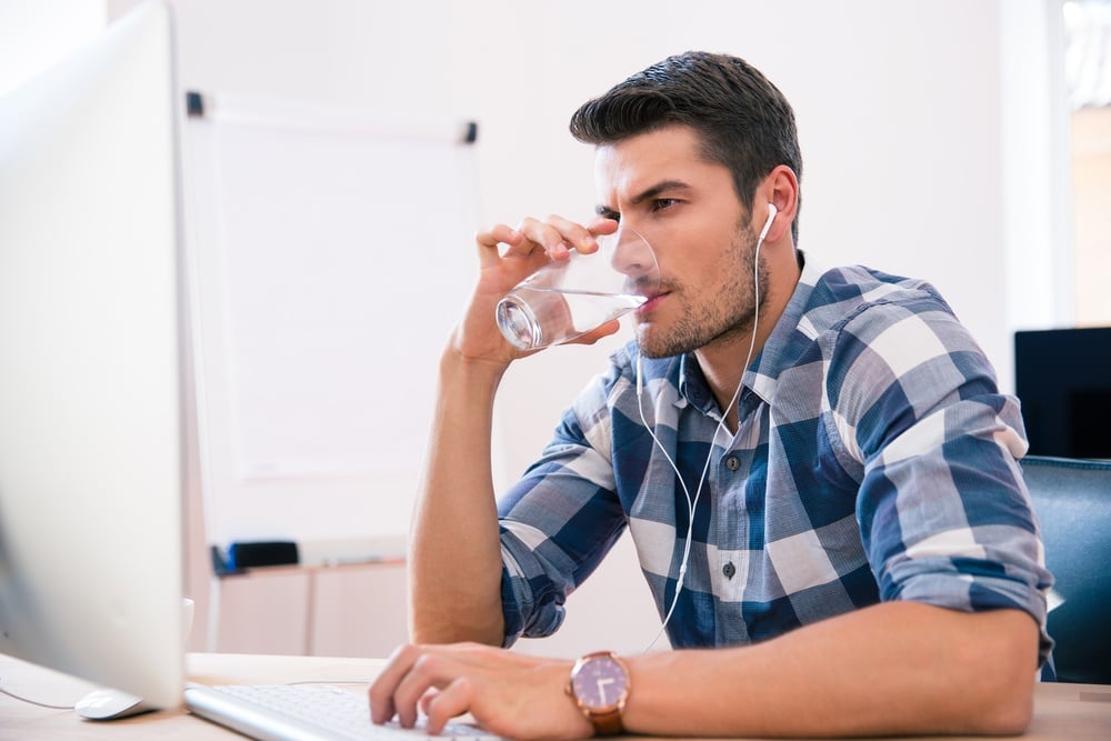 Man drinking water at desk